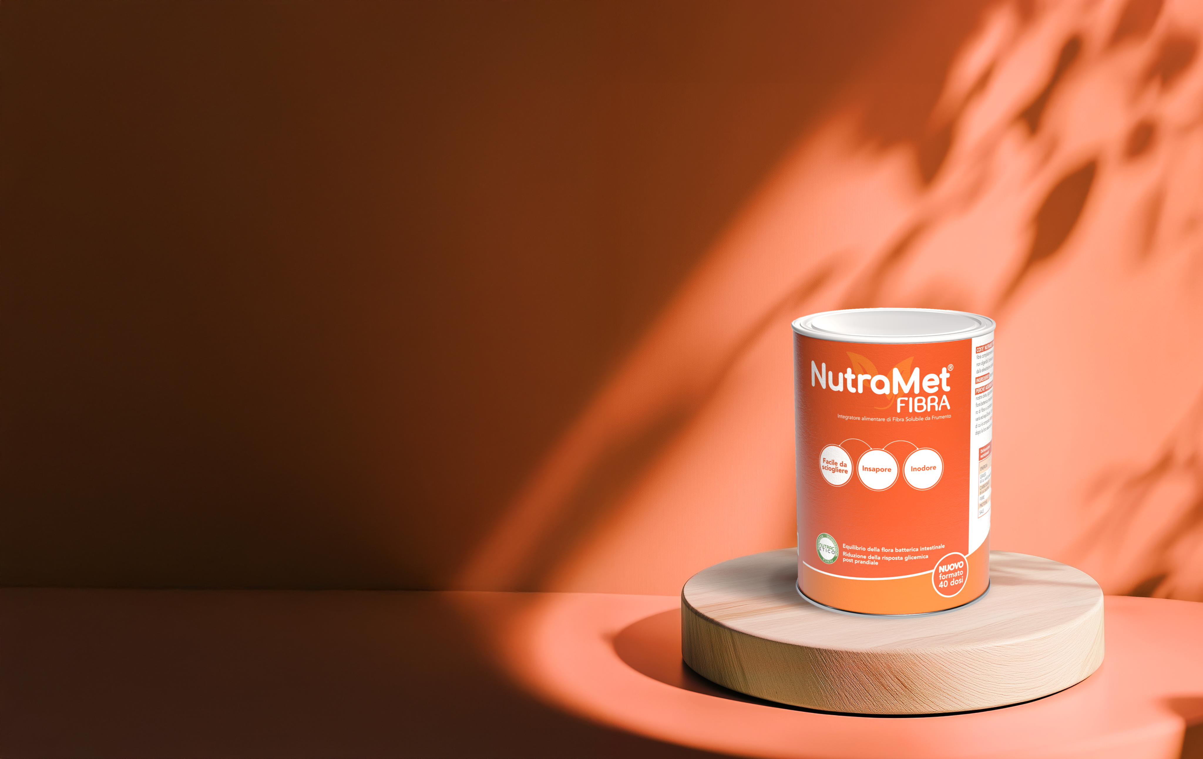 Barattolo di NutraMet Fibra esposto su piedistallo in legno, con sfondo arancione e luce calda.