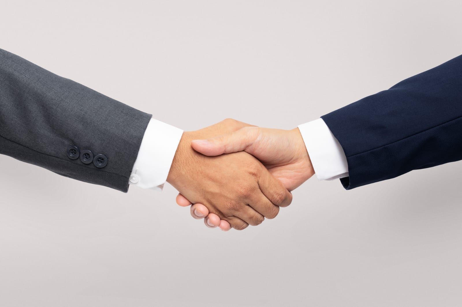 Stretta di mano tra due professionisti in abito formale, simbolo di accordo o partnership