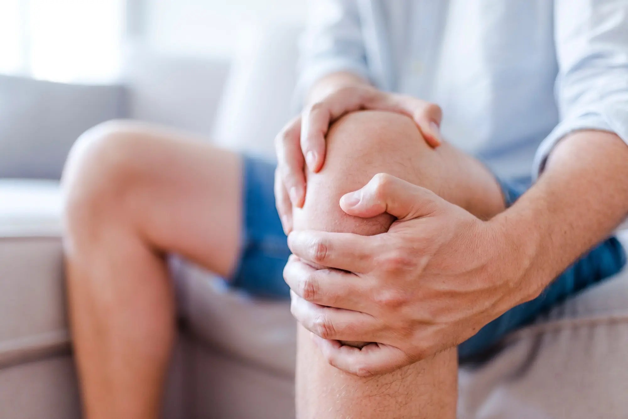 Persona che si massaggia il ginocchio, simbolo di benessere cutaneo e supporto al microcircolo