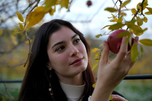 Donna che tocca melograno ricco di antiossidanti
